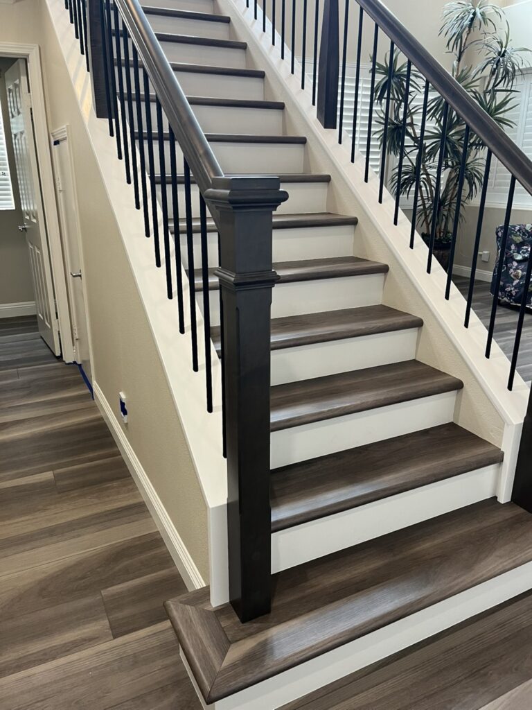 Wooden staircase with black metal railing.