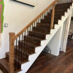 Wooden staircase with metal railings and shelves.