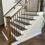Wooden staircase with black metal railings.