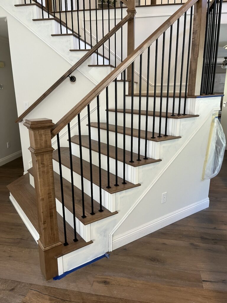 Wooden staircase with black metal railings.