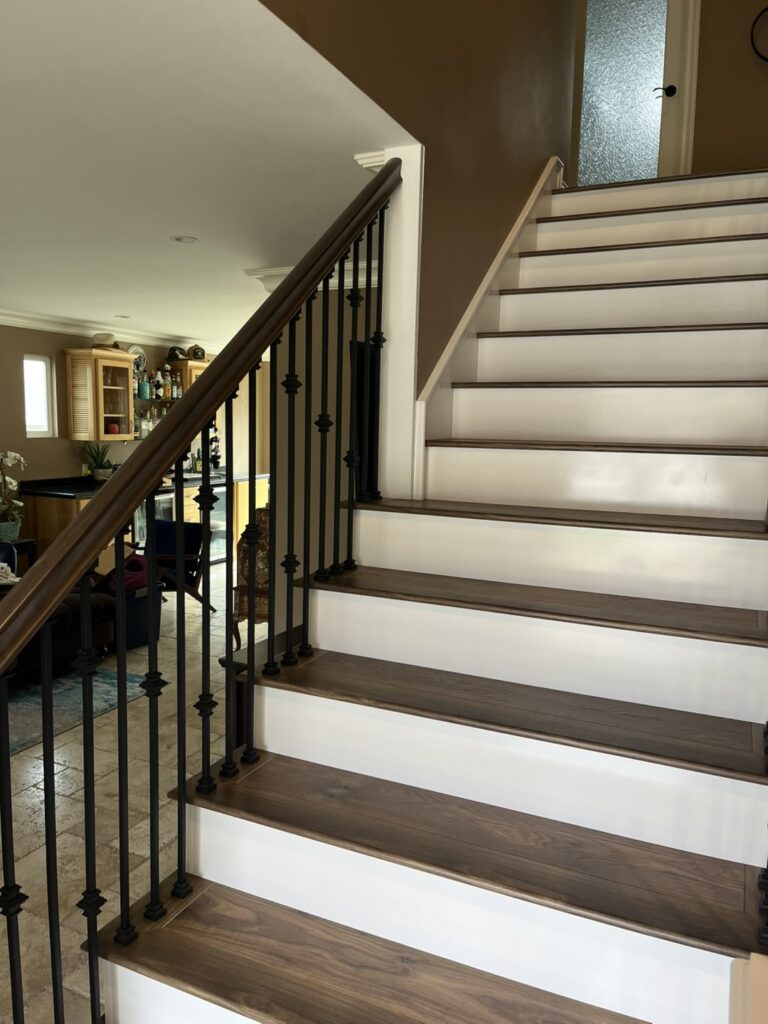 Wooden staircase with black metal railing.