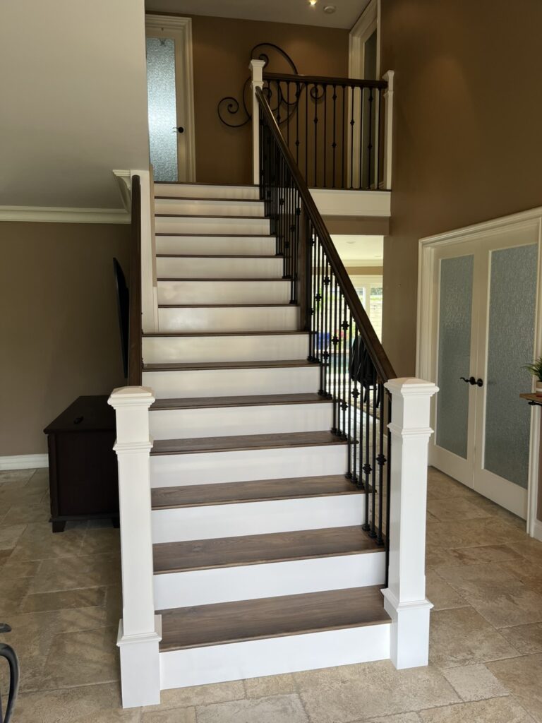Wooden staircase with wrought iron railing.