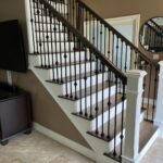 Wooden staircase with black metal railings.