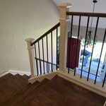 Wooden staircase with black metal railings.