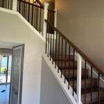 Staircase with white railing and beige walls.
