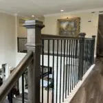 Upstairs hallway with wooden railing and artwork.