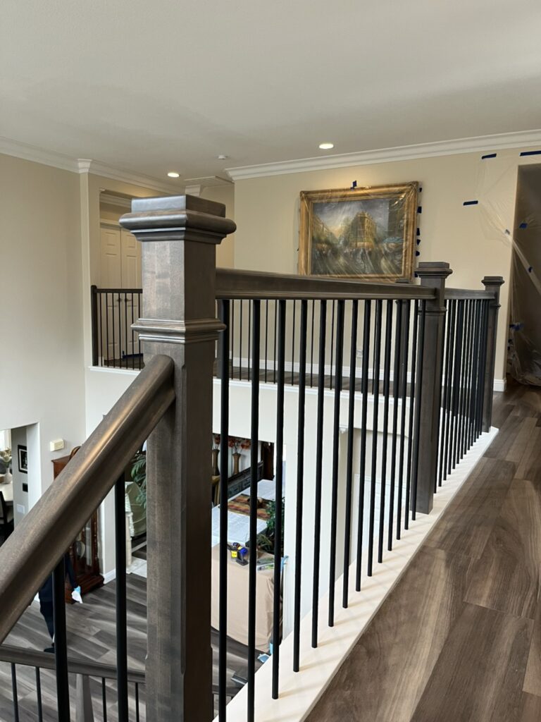 Upstairs hallway with wooden railing and artwork.