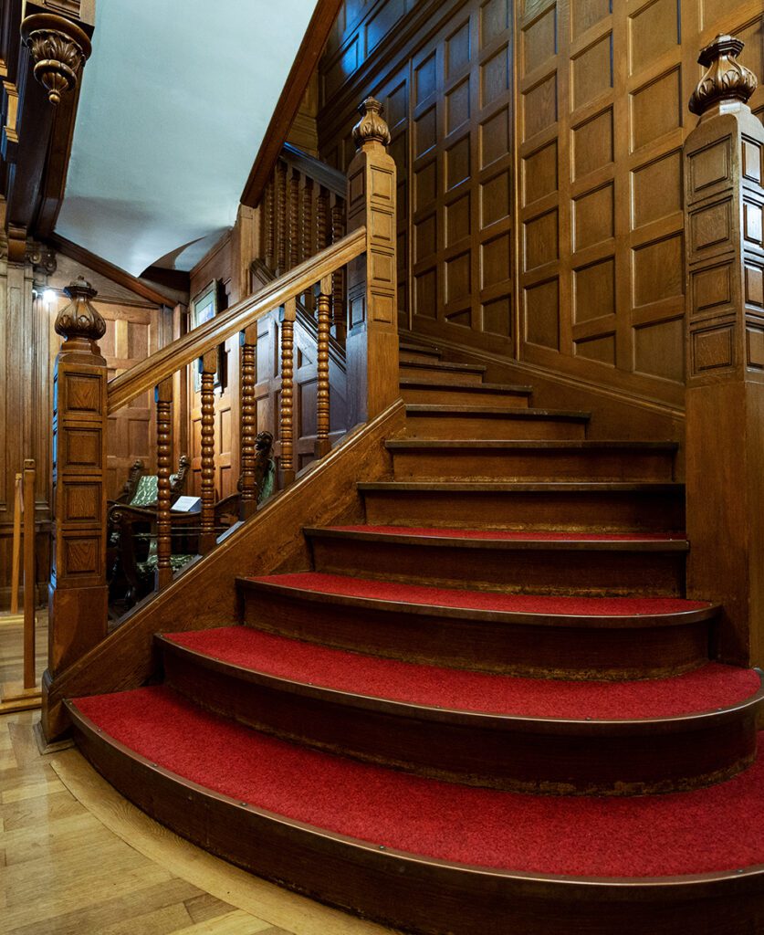 Pelisor Castle interior in Romania. Corridor with wooden stairs made classic style
